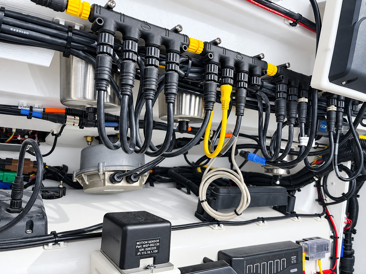 Retouched owner-supplied photograph of marine network connectors and cabling behind a yacht helm